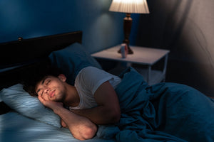 young man sleeping in bedroom at night